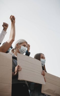 Bir grup aktivist mitingde slogan atıyorlar. Erkekler ve kadınlar şehirde bir protestoda birlikte yürüyorlar..