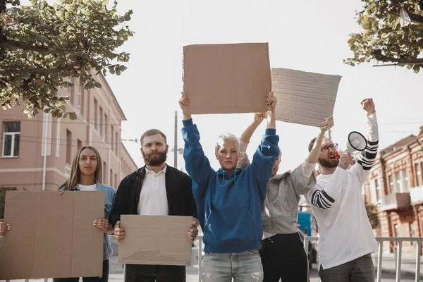 Skupina aktivistů, kteří dávají slogany na shromáždění. Muži a ženy pochodují společně na protest ve městě. — Stock fotografie