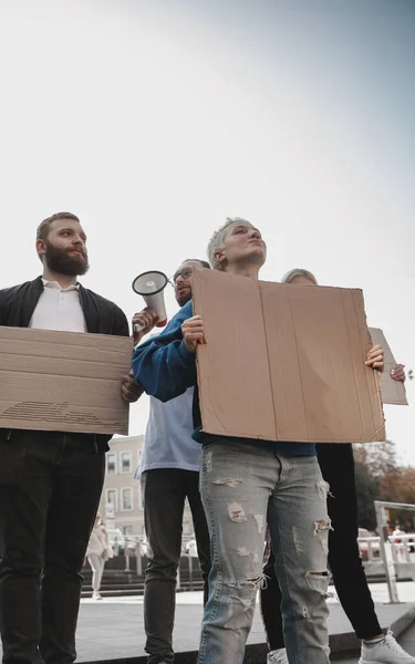 Skupina aktivistů, kteří dávají slogany na shromáždění. Muži a ženy pochodují společně na protest ve městě. — Stock fotografie