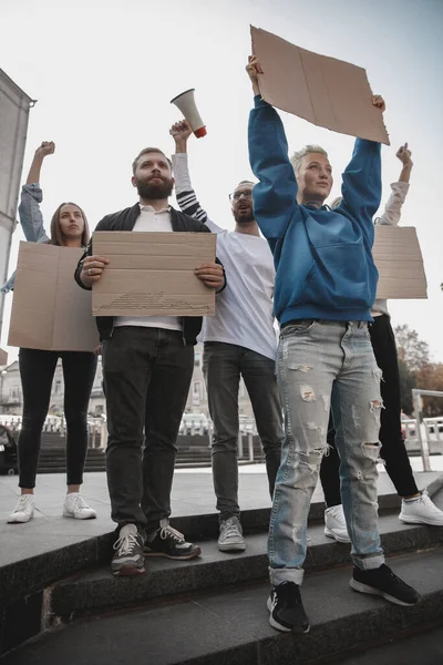 Skupina aktivistů, kteří dávají slogany na shromáždění. Muži a ženy pochodují společně na protest ve městě. — Stock fotografie