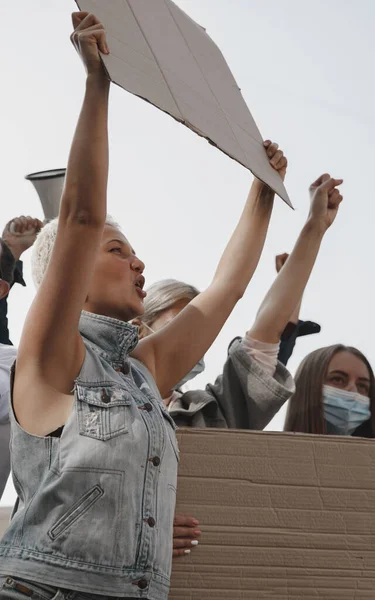 En grupp aktivister som ger paroller i ett möte. Män och kvinnor marscherar tillsammans i en protest i staden. — Stockfoto