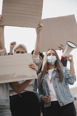 Bir grup aktivist mitingde slogan atıyorlar. Erkekler ve kadınlar şehirde bir protestoda birlikte yürüyorlar..