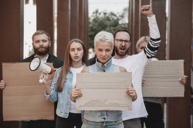 Bir grup aktivist mitingde slogan atıyorlar. Erkekler ve kadınlar şehirde bir protestoda birlikte yürüyorlar..