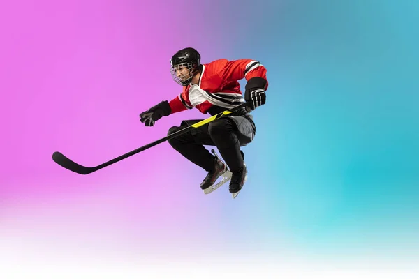 Männlicher Hockeyspieler mit dem Stock auf dem Eis und neonfarbenem Hintergrund. Sportler trägt Ausrüstung, Helm. — Stockfoto