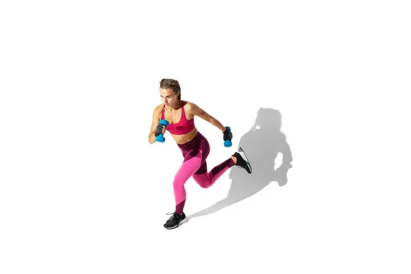 Hermosa joven atleta practicando en el fondo blanco del estudio con sombras — Foto de Stock