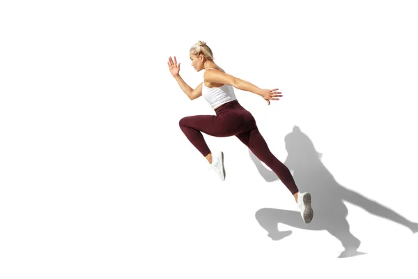 Linda jovem atleta praticando no fundo do estúdio branco com sombra — Fotografia de Stock