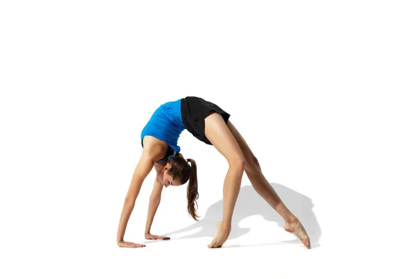 Mooie jonge vrouwelijke atleet stretching op witte studio achtergrond met schaduwen — Stockfoto