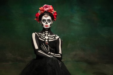 Santa Muerte suretinde genç bir kız, Azize ölümü ya da parlak makyajlı şeker kafatası. Stüdyo arka planında izole edilmiş portre.
