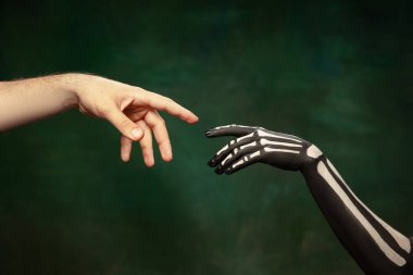 Santa Muerte 'nin eli, Aziz Ölüm ya da Tanrı' nın dokunuşu gibi koyu yeşil arka planda izole edilmiş parlak makyajlı Şeker Kafatası.