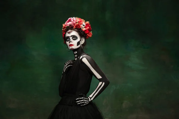 Молодая девушка в образе Санта-Муэрте, Святой смерти или Сахарного черепа с ярким макияжем. Портрет изолирован на фоне студии. — стоковое фото