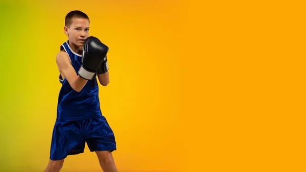 Boxeador adolescente contra gradiente neón fondo del estudio en movimiento de patadas, boxeo —  Fotos de Stock
