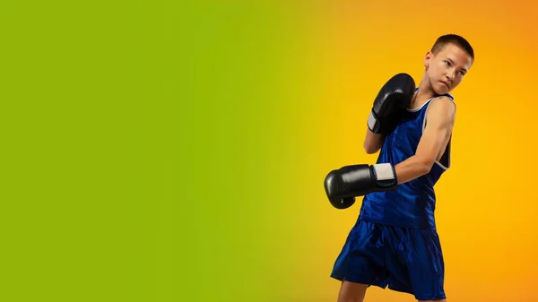 Tonåring boxare mot lutning neon studio bakgrund i rörelse av sparkar, boxning — Stockfoto