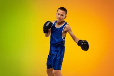 Genç boksör, neon stüdyonun arka planına karşı tekmeleme ve boks yapıyor.