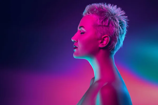 Ritratto di modella femminile in luce al neon su sfondo scuro. — Foto Stock