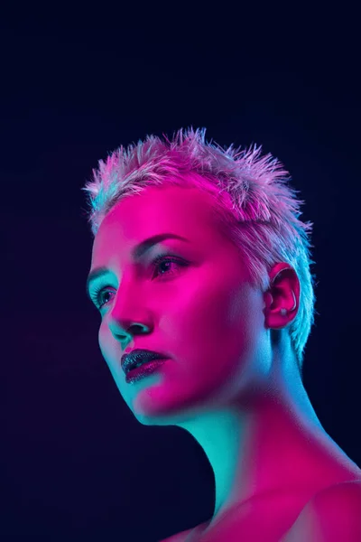 Portrait of female fashion model in neon light on dark studio background. — Stok Foto