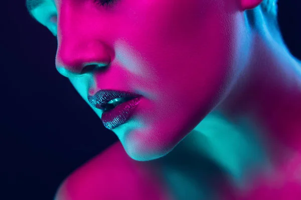 Portret van vrouwelijke mode model in neon licht op donkere studio achtergrond. — Stockfoto