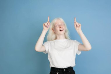 Mavi stüdyo arka planında izole edilmiş güzel beyaz albino kız portresi