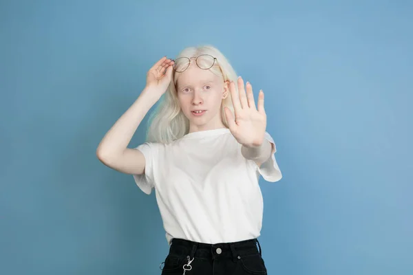 Portrait of beautiful caucasian albino girl isolated on blue studio background — Stok Foto