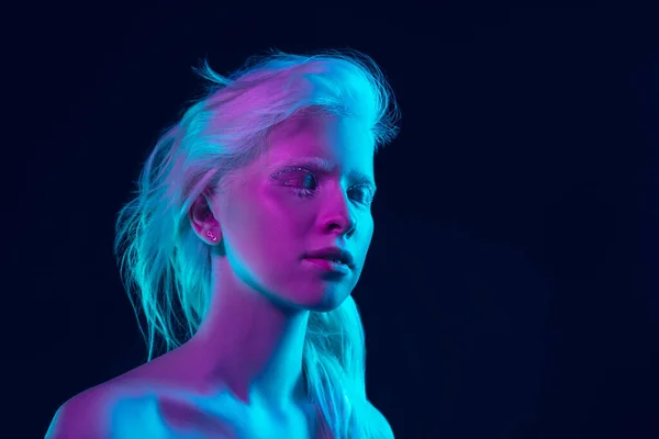Portrét krásné albíny dívka izolované na tmavém pozadí studia v neonovém světle — Stock fotografie