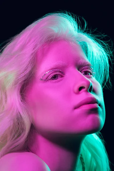 Portret van mooi albino meisje geïsoleerd op donkere studio achtergrond in neon licht — Stockfoto