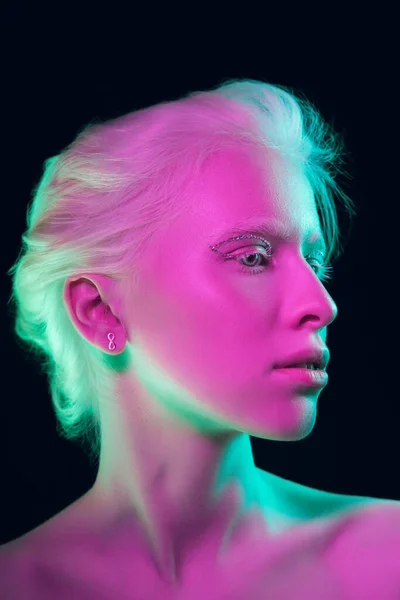 Portrait of beautiful albino girl isolated on dark studio background in neon light — Stock Photo, Image