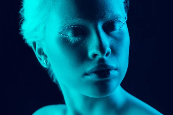 네온 빛으로 어두운 스튜디오 배경에 고립 된 아름다운 알비노 소녀의 모습 — 스톡 사진