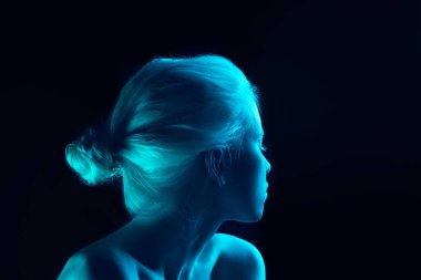 Güzel albino bir kızın portresi. Karanlık stüdyo arka planında neon ışıkta izole edilmiş.