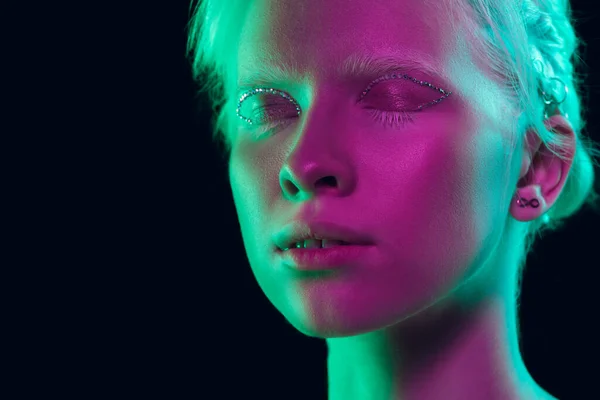Portrait of beautiful albino girl isolated on dark studio background in neon light — Stock Photo, Image