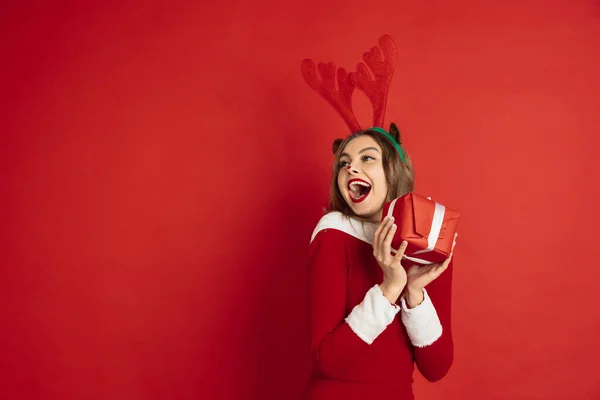 Belle femme comme cerf de Noël isolé sur fond rouge. Concept de 2021 Nouvel An, ambiance hivernale, vacances. — Photo