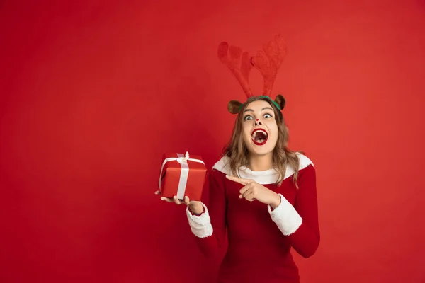 Красивая женщина, как Рождественский олень изолированы на красном фоне. Концепция 2021 года Новый год, зимнее настроение, праздники. — стоковое фото