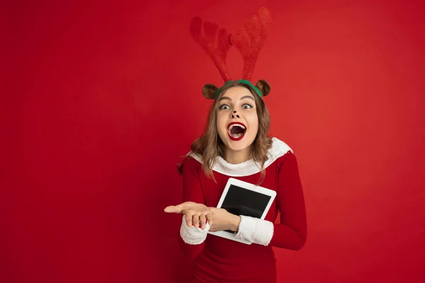 Красивая женщина, как Рождественский олень изолированы на красном фоне. Концепция 2021 года Новый год, зимнее настроение, праздники. — стоковое фото