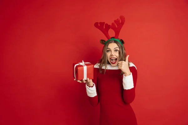 Belle femme comme cerf de Noël isolé sur fond rouge. Concept de 2021 Nouvel An, ambiance hivernale, vacances. — Photo