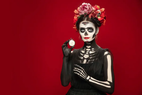 Jong meisje naar het beeld van Santa Muerte, Sint dood of Suikerschedel met heldere make-up. Portret geïsoleerd op studio achtergrond. — Stockfoto