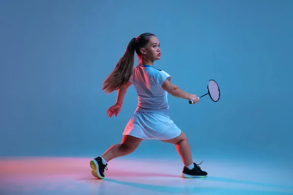 Bella donna nana che pratica a badminton isolato su sfondo blu in luce al neon — Foto Stock