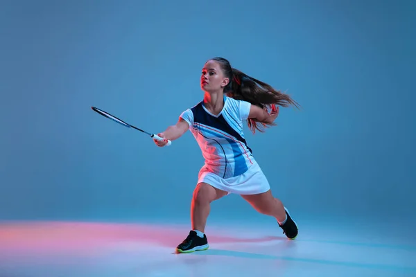 Bella donna nana che pratica a badminton isolato su sfondo blu in luce al neon — Foto Stock