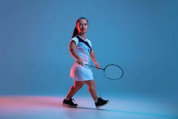 Bella donna nana che pratica a badminton isolato su sfondo blu in luce al neon — Foto Stock