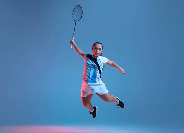 Vacker dvärg kvinna tränar i badminton isolerad på blå bakgrund i neon ljus — Stockfoto
