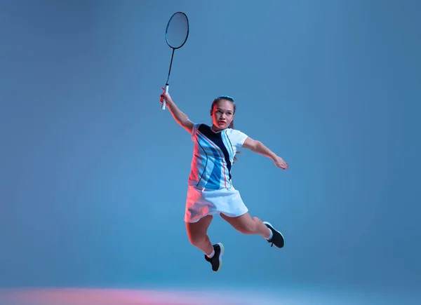 Bella donna nana che pratica a badminton isolato su sfondo blu in luce al neon — Foto Stock