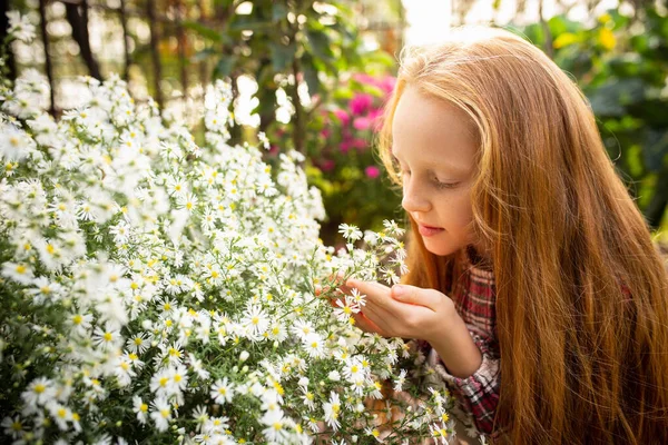Gadis kecil yang bahagia dengan bunga di taman luar — Stok Foto
