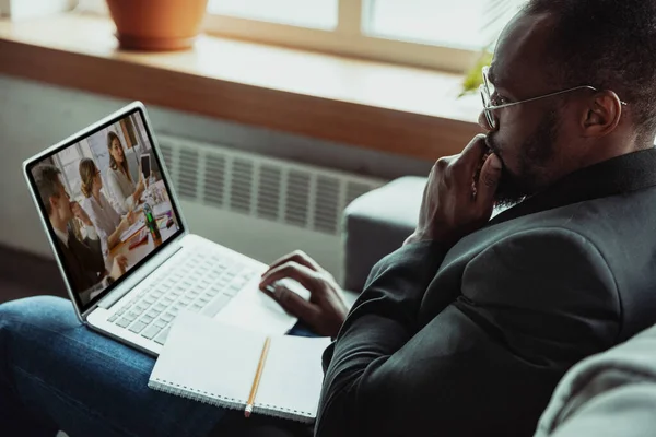 Человек, работающий на дому, концепция удаленного офиса. Молодой бизнесмен, менеджер, выполняющий задачи с ноутбуком, провел онлайн-конференцию. — стоковое фото