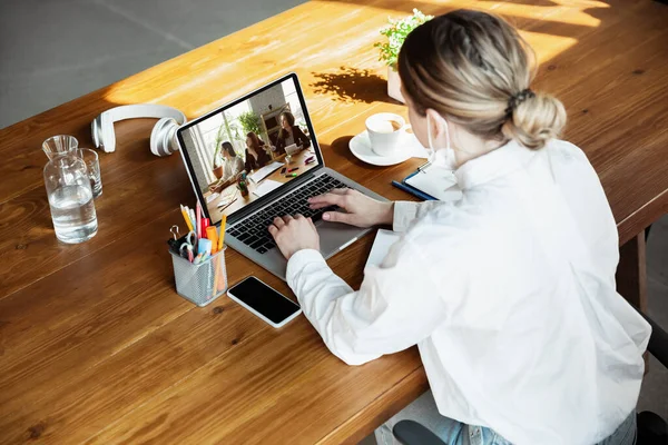 Молодой врач, работающий онлайн с ноутбуком, проводит онлайн-конференцию с коллегами с рабочего места — стоковое фото