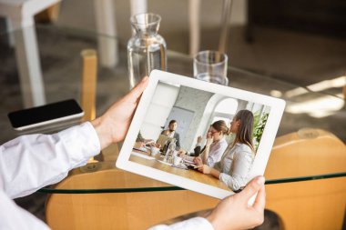 Bilgisayarla çalışan genç doktor, iş yerindeki meslektaşlarıyla online konferans yapıyor.