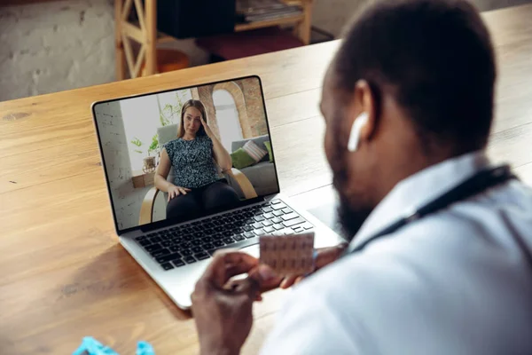 Jeune médecin travaillant en ligne avec un ordinateur portable, a une conférence en ligne avec un collègue de travail — Photo