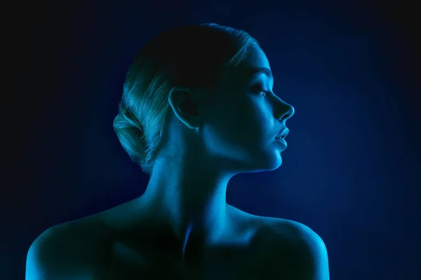 Portrait of female fashion model in neon light on dark studio background. — Stock Photo, Image