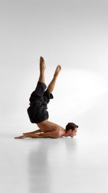 Çıplak erkek gövdesi yerde ters dönmüş yoğun duygu ve vücut kontrolüyle. Farkındalık kavramı, somatik uygulama, kırılganlık ve iç gücün psikolojisi..