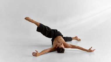 Erkek vücudu geniş kollar ve sessizlikte duygusal açıklıkla yerde uzanıyor. Farkındalık, somatik uygulama, beden eğitimi ve durgunluk yoluyla duygusal farkındalık kavramı.