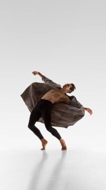 Erkek dansçı, dramatik duygusal rahatlama ve incinebilirlik ile geriye doğru eğiliyor. Performans sanatı, modern erkeklik, zen kültürü ve kelimesiz vücut anlatımı kavramı.