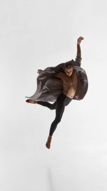 Erkek oyuncu dinamik kolları ve güçlü duygusal hassasiyeti olan paltoyla zıplıyor. Modern erkeklik kavramı, performans sanatı, zen felsefesi ve vücut yoluyla hikaye anlatma..