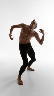 Erkek oyuncu dramatik bir jest ve duygusal hassasiyetle geriye doğru eğiliyor. Kelimesiz görsel hikaye anlatma, zen felsefesi ve sanat yoluyla modern erkeklik kavramı.