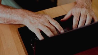 Dizüstü bilgisayarda çalışan ve ellerine odaklanan bir adam. Serbest çalışma alışkanlığı, teknoloji, çevrimiçi iletişim, dijital çalışma ve modern üretkenlik kavramı.